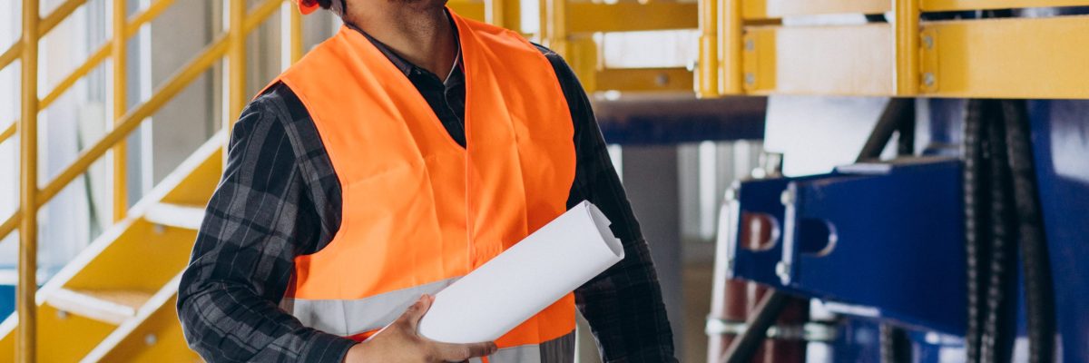 African american worker standing in uniform wearing a safety hat in a factory